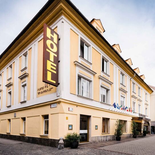 Bild Aussenansicht vom Hotel Mariahilf, ein hellgelbes Haus auf einem Platz.